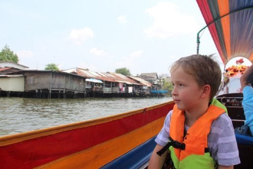 Child enjoying boat ride along canal in Bangkok