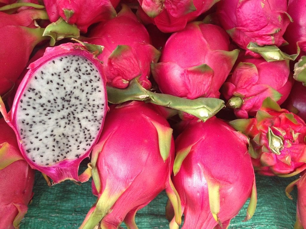 Image of a sliced dragon fruit with its white fresh and small black seeds