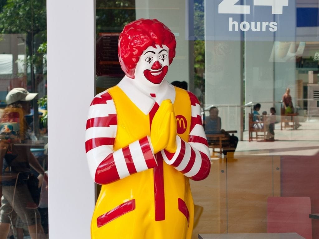 A Ronald McDonald statue making a wai gesture at a branch of McDonald's in Thailand