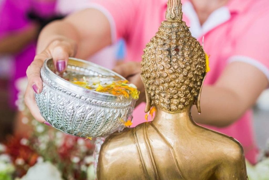 Pouring water over Buddha images